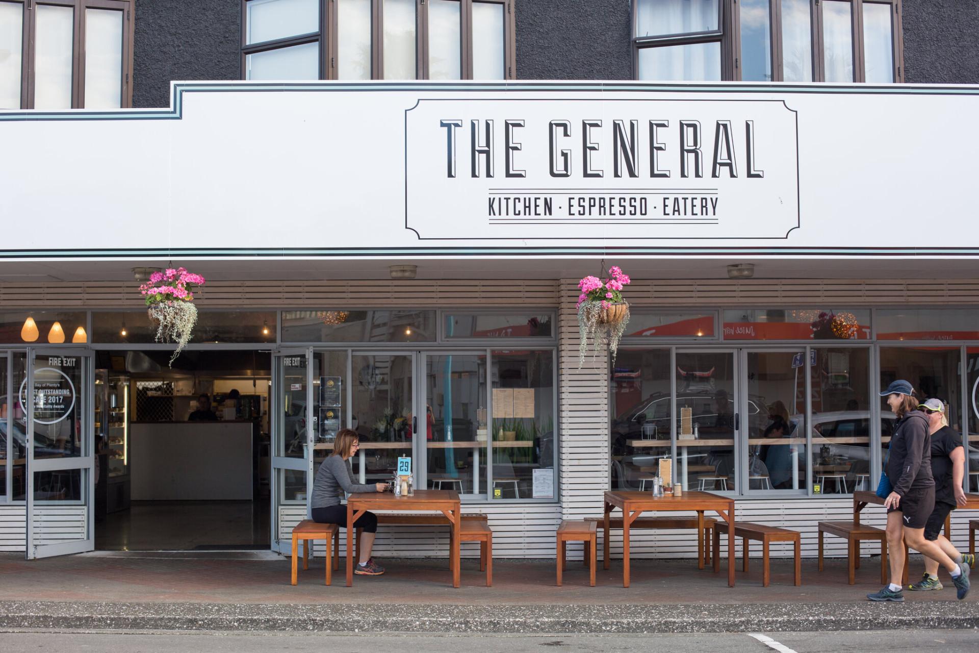 Cafe frontage on Maunganui Road with street seating and passers-by