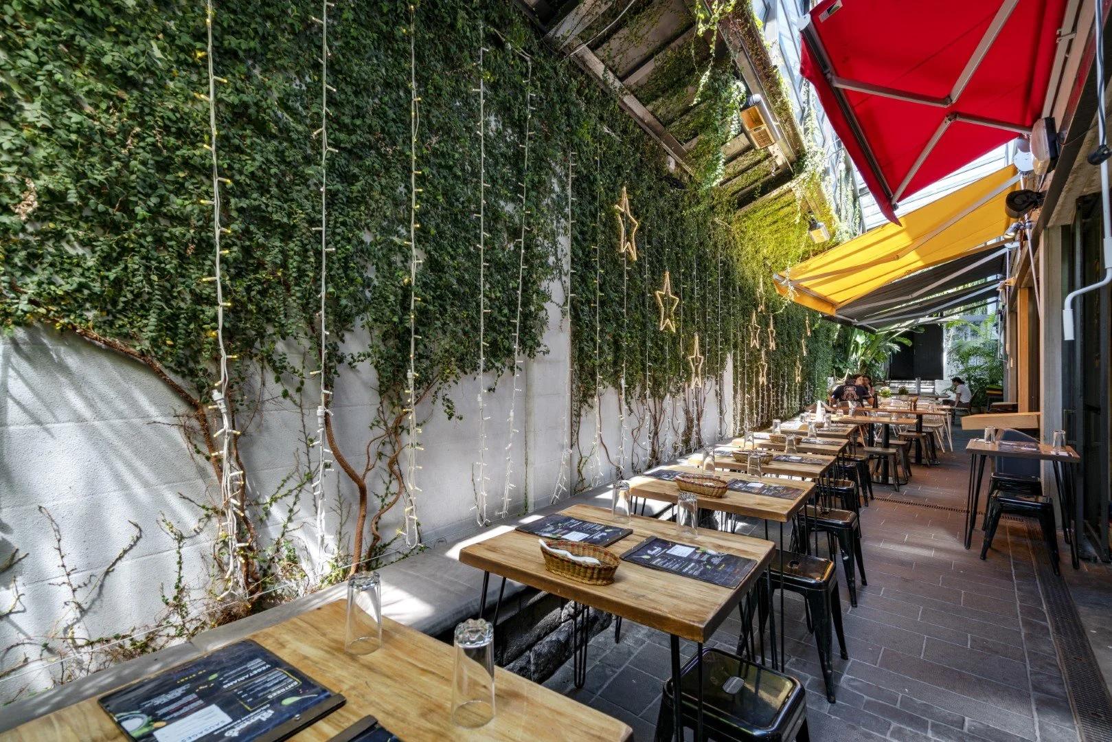 Laneway dining beside a planted wall at the beach end of Hurstmere Road