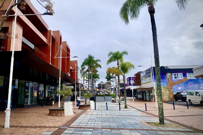 Red Square in central Tauranga, paved plaza edged by shops and palms